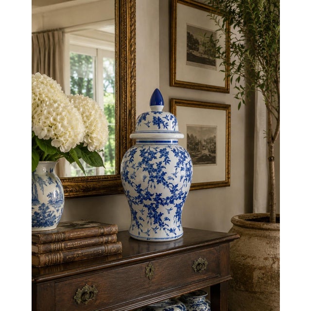 A classic blue and white ginger jar, decorated throughout with delicate bird and flowering branch motifs. The pattern is...