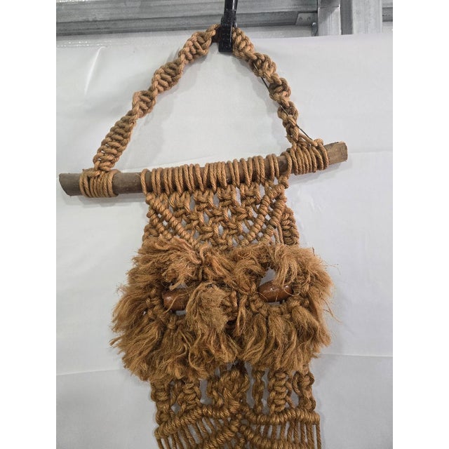 A striking vintage 1970s macramé owl wall hanging, handcrafted in natural fiber rope with intricate knotwork and mounted...