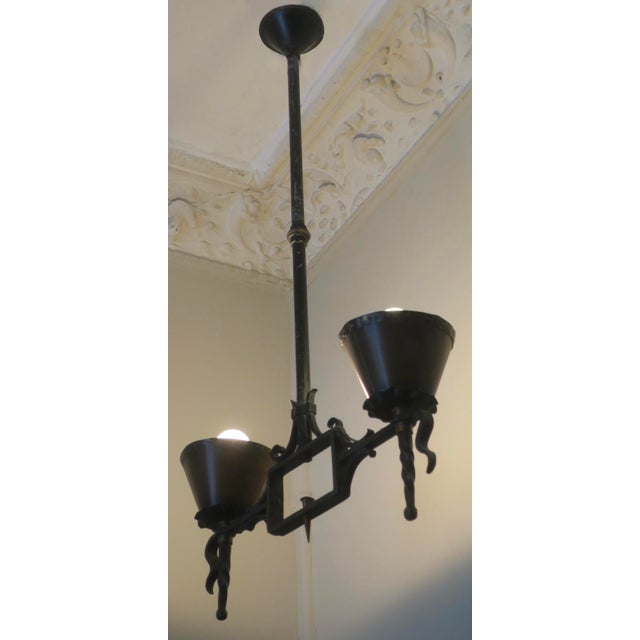 Brutalist 2-arm chandelier in wrought iron with copper shades, dating from the 1960s Up to 250V (Europe/UK Standard).The...