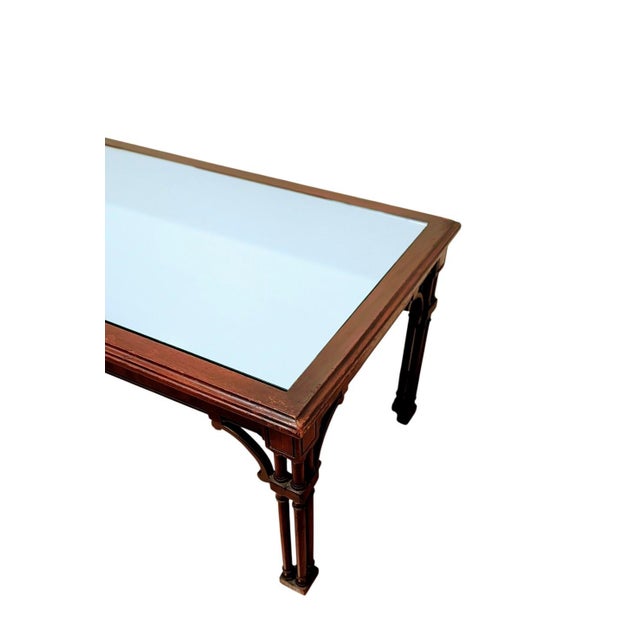 This is a beautiful wooden coffee table with a mirrored glass top, featuring a design quite similar to a vintage Maitland...