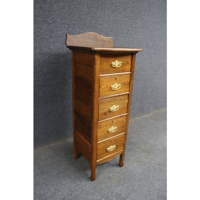 Rare Victorian quarter sawn oak lingerie chest featuring five graduated drawers, decorative brass bail pulls, keyhole...