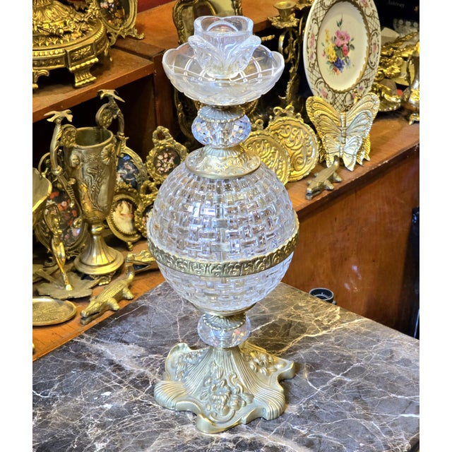 This brass and crystal candlestick holder is a refined decorative accent designed to elevate luxury interiors. Featuring a...