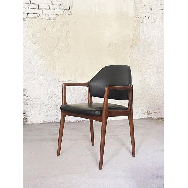 Original Wilkhahn armchair from the 1960s, featuring a rosewood frame and black faux leather upholstery. Based on its...