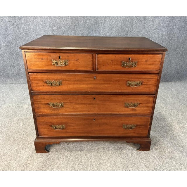 This 18th century solid mahogany chest features a classic two-over-three drawer configuration with richly aged patina and...