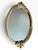 Elegant vintage mirrored vanity tray featuring a warm gold-tone metal frame with sculptural floral and bow-like...