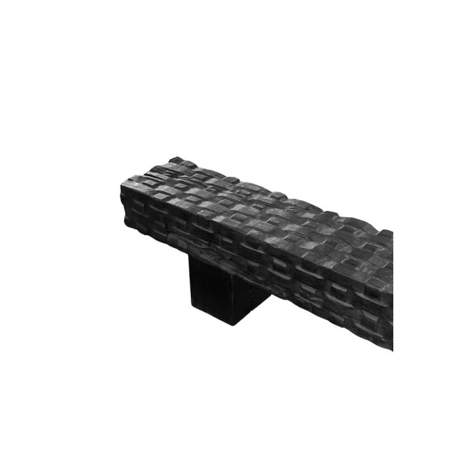 A sculptural hand-carved mango wood bench. To achieve is rich black pigment the bench was burnt three times and then...