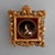 An antique Italian painting offers enamel on copper portrait of a Classical woman seated in reticulated foliate giltwood...