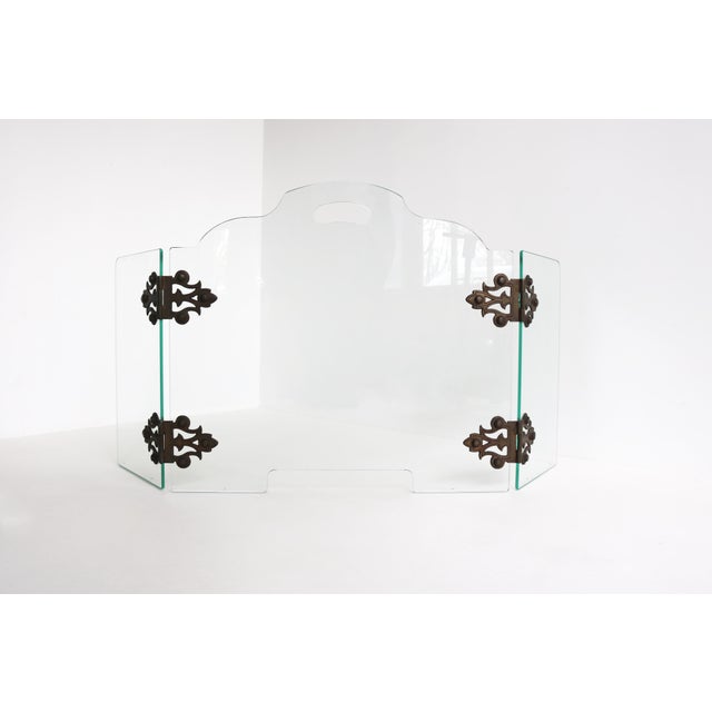 This elegant mid-century modern fire screen features three panels of glass with brass hinges, designed to add a touch of...