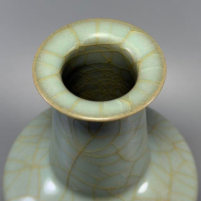A noble Chinese celadon mallet‑form vase, embodying timeless oriental aesthetic. It is enveloped in serene pale celadon...