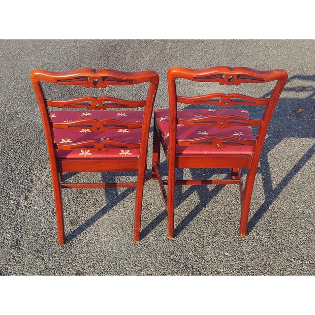 Behold, a whisper of bygone elegance: a matched pair of 19th-century style Chippendale side chairs, their mahogany frames...