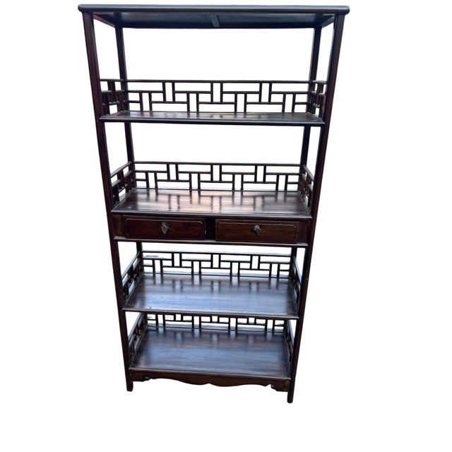 Striking pair of tall Chinese-style rosewood étagères featuring open architectural forms and intricate geometric fretwork...