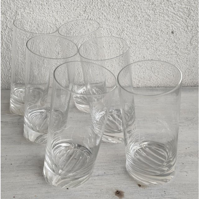 A set of crystal juice glasses with a slanted base, in the style of Angelo Mangiarotti. Unsigned pieces.