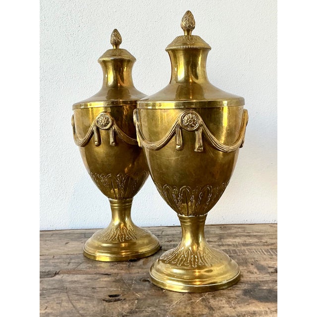 These elegant vintage brass urns are a masterclass in Neoclassical grace and Hollywood Regency flair. Each vessel is...
