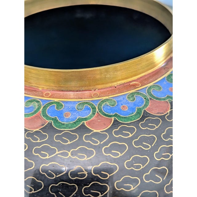 Elaborately detailed Cloisonné with peonies, leaves and a butterfly against a black finish studded with clouds. Hints of...