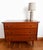 Vintage Scandinavian-style chest of drawers with splayed legs and brass-plated feet. High-gloss lacquered wood, three...