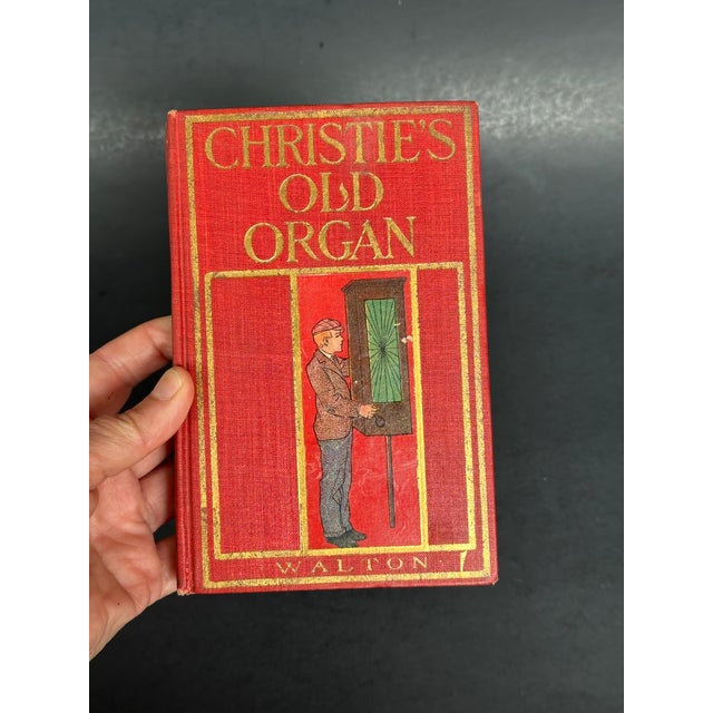 This antique Victorian era book has a charming decorative cover with an illustration of an old fashioned organ grinder....