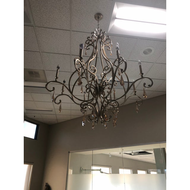 Beautiful chandelier with an antique champaign finish, graceful scroll design, and hanging amber colored crystal accents....