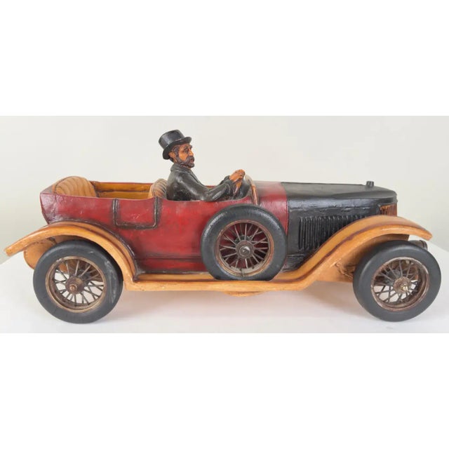 A meticulously crafted 1913 model touring automobile. The car model features a two-tone color scheme, predominantly black...