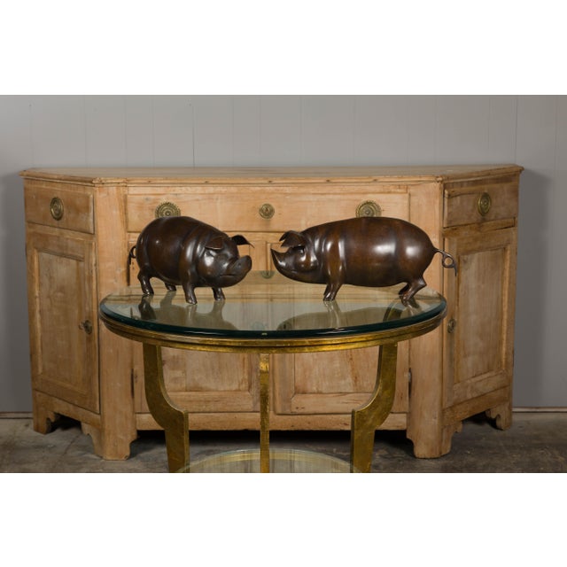 A pair of American bronze pig sculptures from circa 1950-1970 in dark patina. These charming American bronze pig...