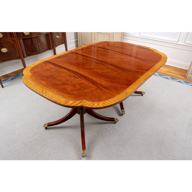 A Regency style double pedestal dining table with a high-gloss French-polished finish, highly figured mahogany top, wide...