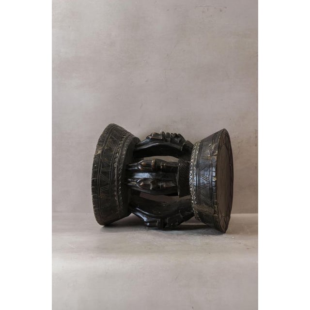 This Baule wood carved vintage stool is a stunning piece of traditional African craftsmanship. Hand-carved from solid wood...