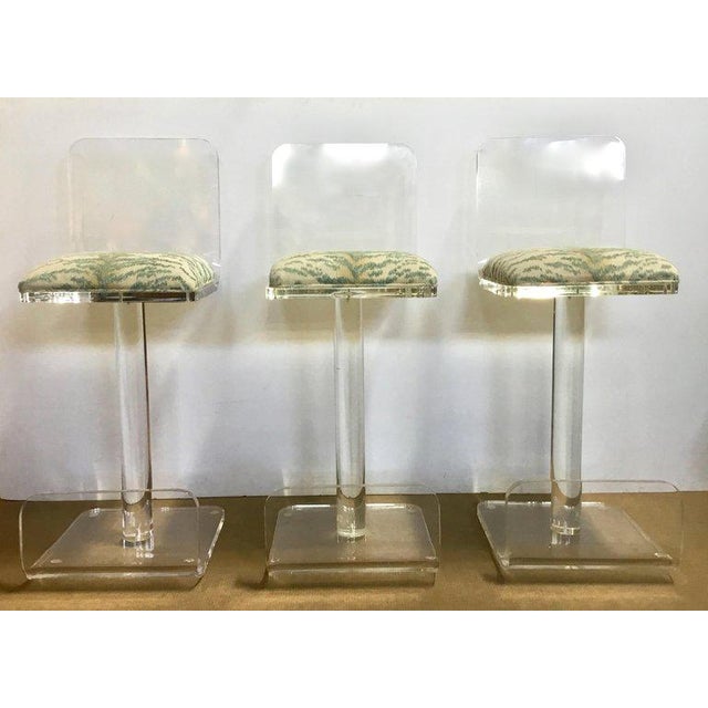Set of three Lucite bar stools, single stem centre support, with clear Lucite base and back. Freshly upholstered seat (no...