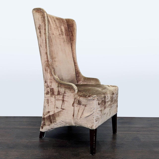 Modified wingback chair on wood legs covered in champagne velvet. Dimensions (in): 20W x 22D x 47H.