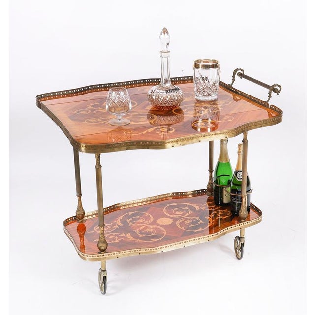 This is a very entertaining vintage walnut and satin wood two-tier Italian Sorrento drinks trolley, mid-20th century in...