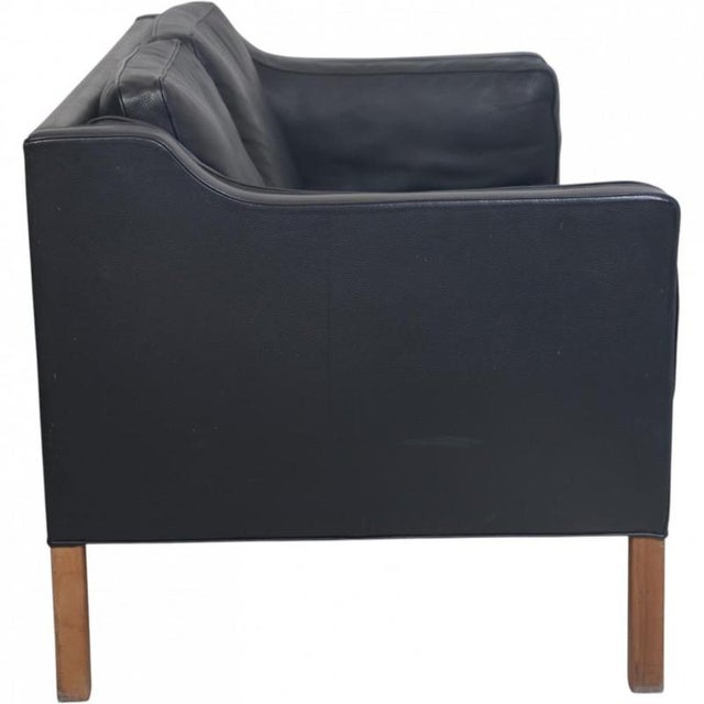Børge Mogensen 2212 2.seater sofa upholstered in black leather and with legs of teak. The sofa is from the 1980s but was...