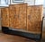This is a British Art Deco Cocktail Bar Cabinet attributed to Harry and Lou Epstein. The figure of the burled walnut wood...