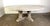 Monumental size neoclassical style round dining table with a distressed, rustic finish. Its design features intricately...