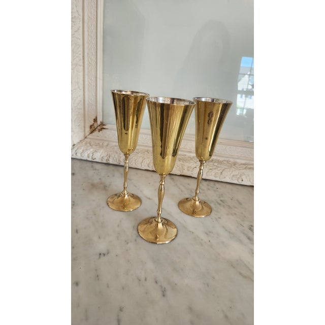 A handsome set of three vintage brass-plated metal goblets made in India, each distinguished by a tall tapered bowl,...