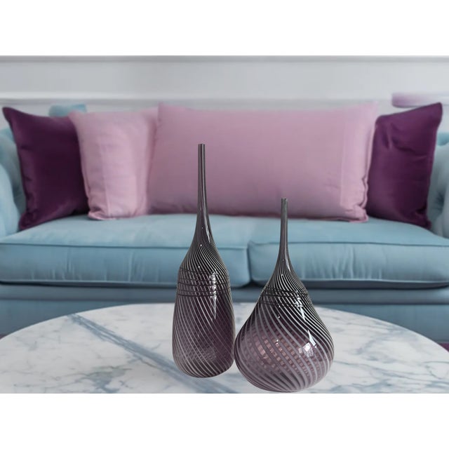 This striking pair of mid-century modern style art glass vases is crafted from a translucent amethyst purple glass...