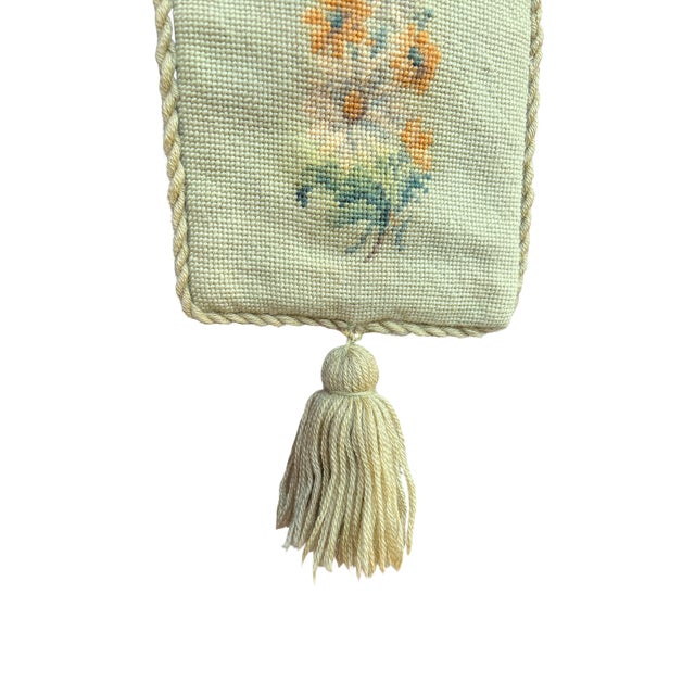 A beautifully worked vintage needlepoint bell pull featuring a soft celadon ground adorned with delicate vertical bouquets...
