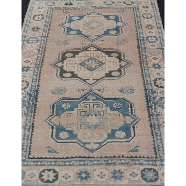 Measures: 4'9 x 7'6 This Vintage Turkish Oushak rug is a captivating piece that brings together soft beige and blue tones...