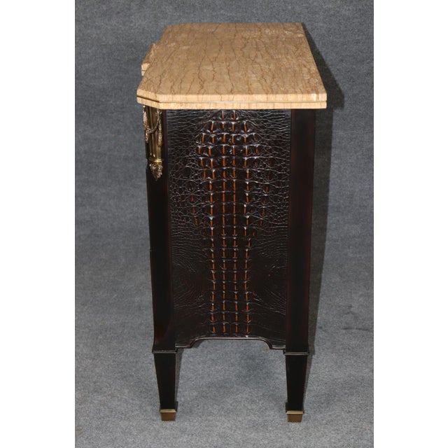 An elegant and distinctive Louis XVI-style commode by Theodore Alexander, combining classical French design with exotic...