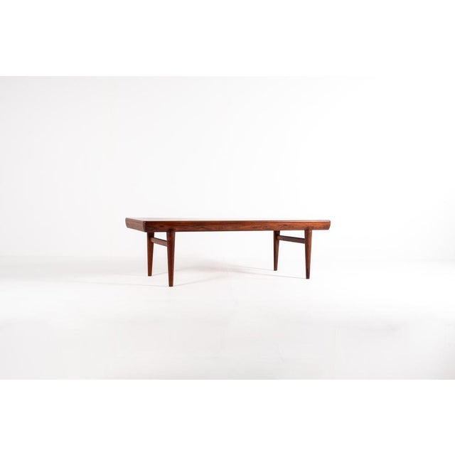 This stunning rosewood coffee table was designed by Johannes Andersen for CFC Silkeborg in Denmark. It features an...