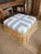 Woven rattan ottoman newly upholstered in a crisp, timeless blue-and-white cabana stripe fabric. Tightly woven natural...