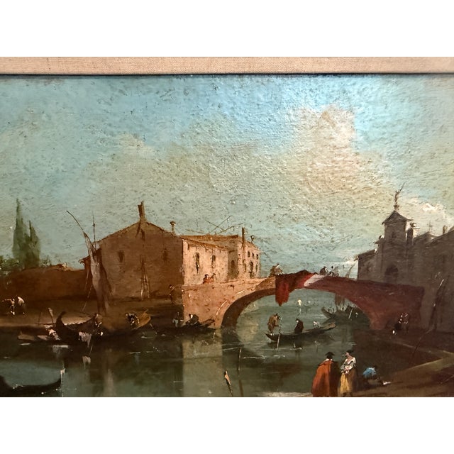 This refined antique oil on board depicts a tranquil Venetian canal scene with gondolas gliding across calm water beneath...