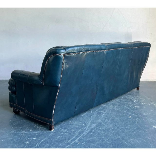 This imposing vintage sofa offers a luxurious and dramatic interpretation of the classic English Chesterfield, upholstered...