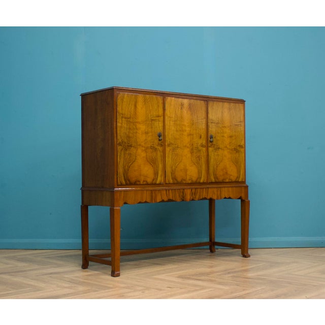 A beautiful walnut sideboard or drinks cabinet by Waring and Gillow, circa 1930s. Featuring two cupboards with shelves and...