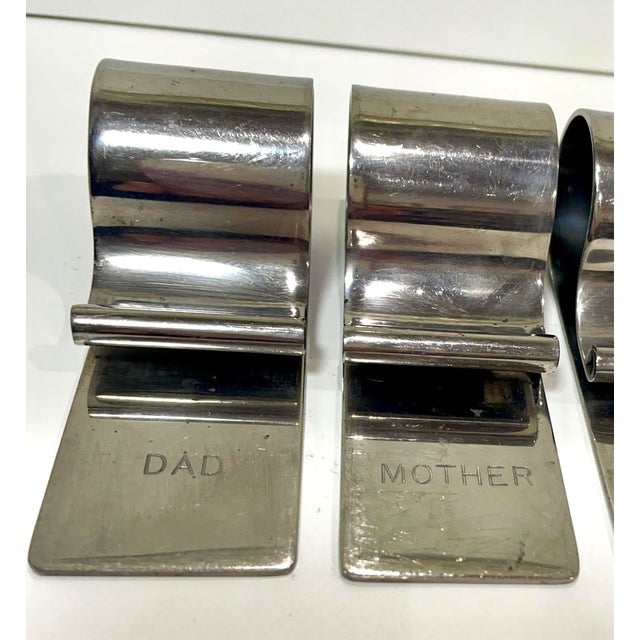 A set of six vintage silver napkin clip holders. Each napkin holder has a name engraved on them. The first is DAD, the...