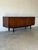 This exceptional low credenza showcases striking symmetrical grain patterns across its entire front profile. Elegant...