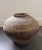 Chinese Banshan style unglazed earthenware jar with a tapered body and textured sides.