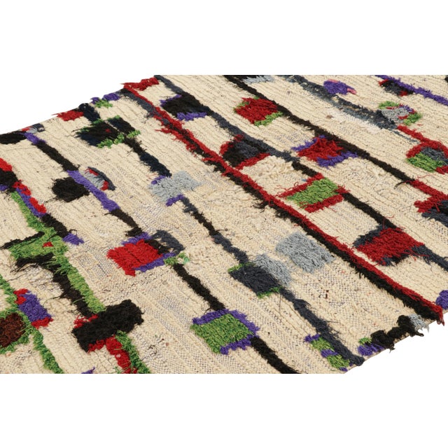 Hand-knotted in wool and originating from Morocco circa 1950-1960, this 5x8 vintage Moroccan rug is an extremely rare...