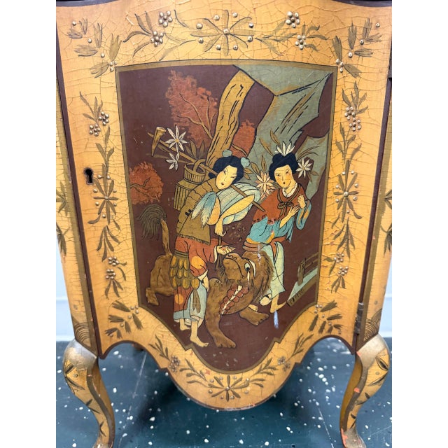 Vintage Chinoiserie accent cabinet featuring hand-painted Asian figural and floral scenes, decorative hardware, curved...