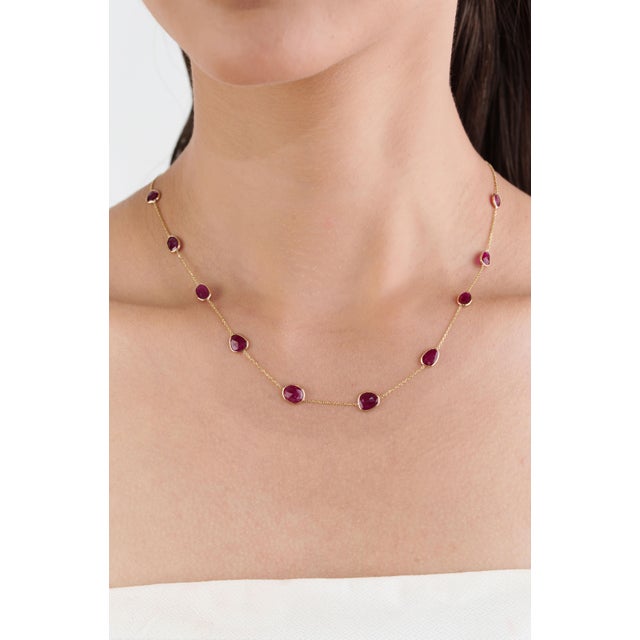 This elegant station necklace showcases 6.95 carats of natural uneven, mixed shapes rubies, set in 14K yellow gold. Each...