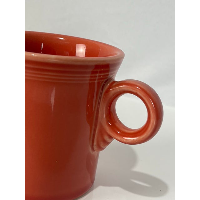 Classic Fiesta Ware ring-handle coffee cup in the warm Persimmon glaze, featuring the iconic concentric detailing around...