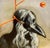 This artwork features a figure with a striking bird-like mask, accentuated by flowing white hair and a vivid orange sun in...