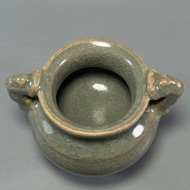 Fine Chinese Longquan celadon tripod censer with twin beast handles and natural crackled glaze. Elegant classic shape,...